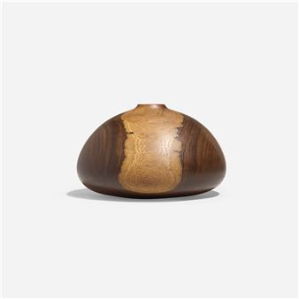 a wooden vase sitting on top of a white surface