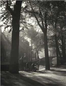 A black and white photo of people sitting on a bench in a park.
