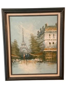 A framed painting of a Parisian street scene featuring the Eiffel Tower and a couple walking.