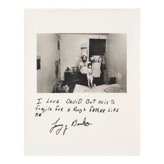 A black-and-white photograph of a man and child in a bedroom, accompanied by handwritten text.