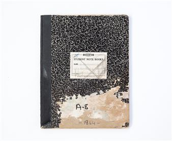 A weathered black-and-white notebook with a torn label and handwritten markings.