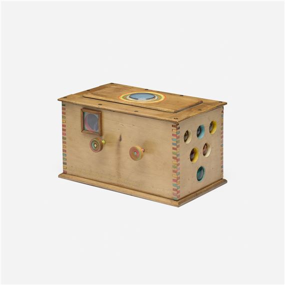 A wooden sensory box with colorful knobs and holes.