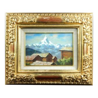 A framed landscape painting of a snowy mountain peak above rustic buildings.