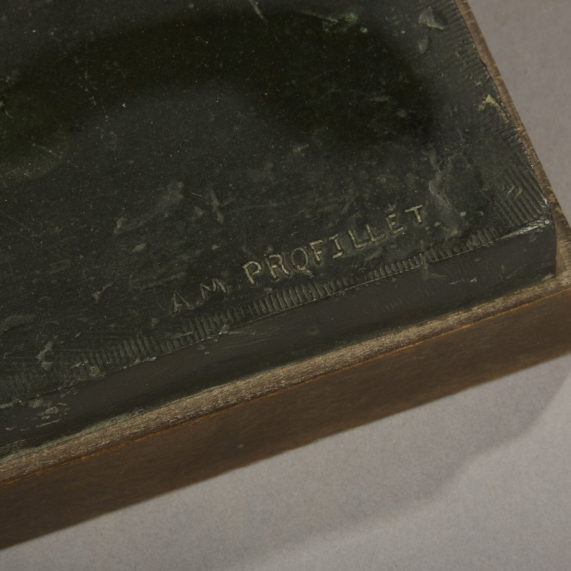 A bronze sculpture of a lion on a wooden base.