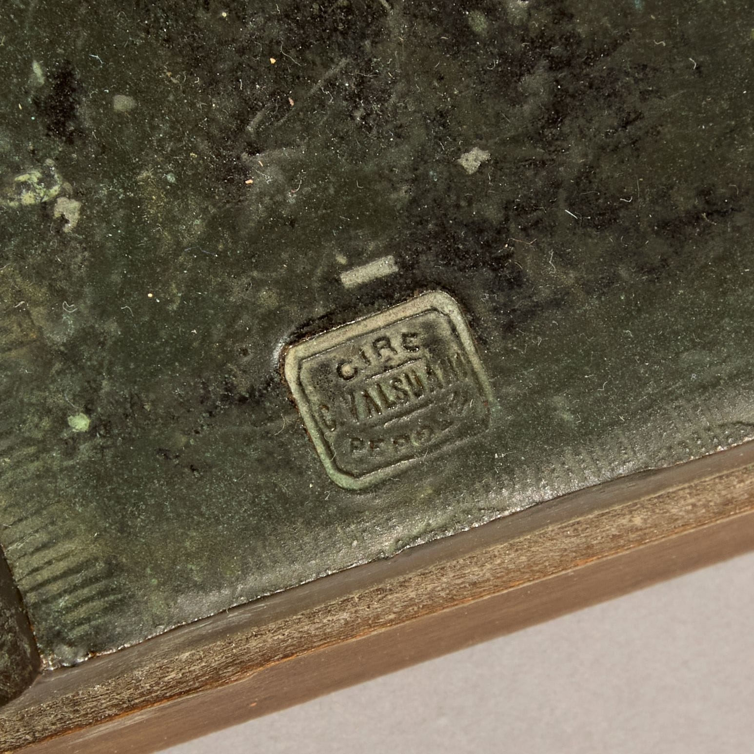 A bronze sculpture of a lion on a wooden base.