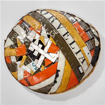A spherical sculpture composed of fragmented printed paper strips forming a chaotic, colorful mosaic.