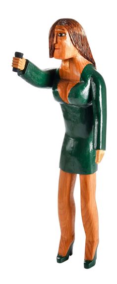 A wooden figurine of a woman in a green dress holding a microphone.