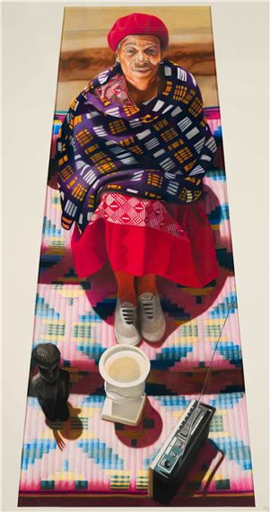 A vertical portrait of a seated figure in vibrant traditional attire, surrounded by everyday objects on a colorful geometric rug.
