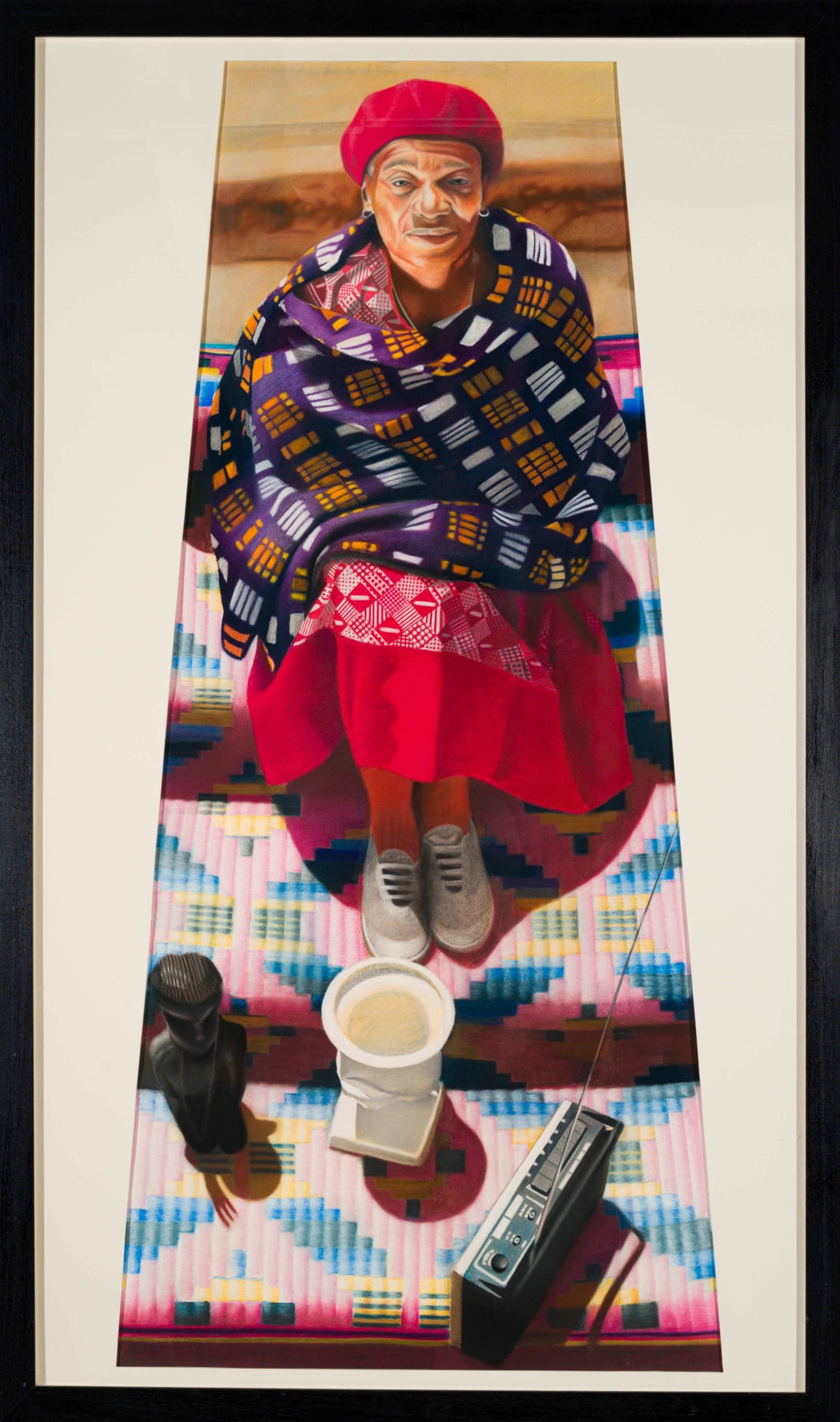 A vertical portrait of a seated figure in vibrant traditional attire, surrounded by everyday objects on a colorful geometric rug.