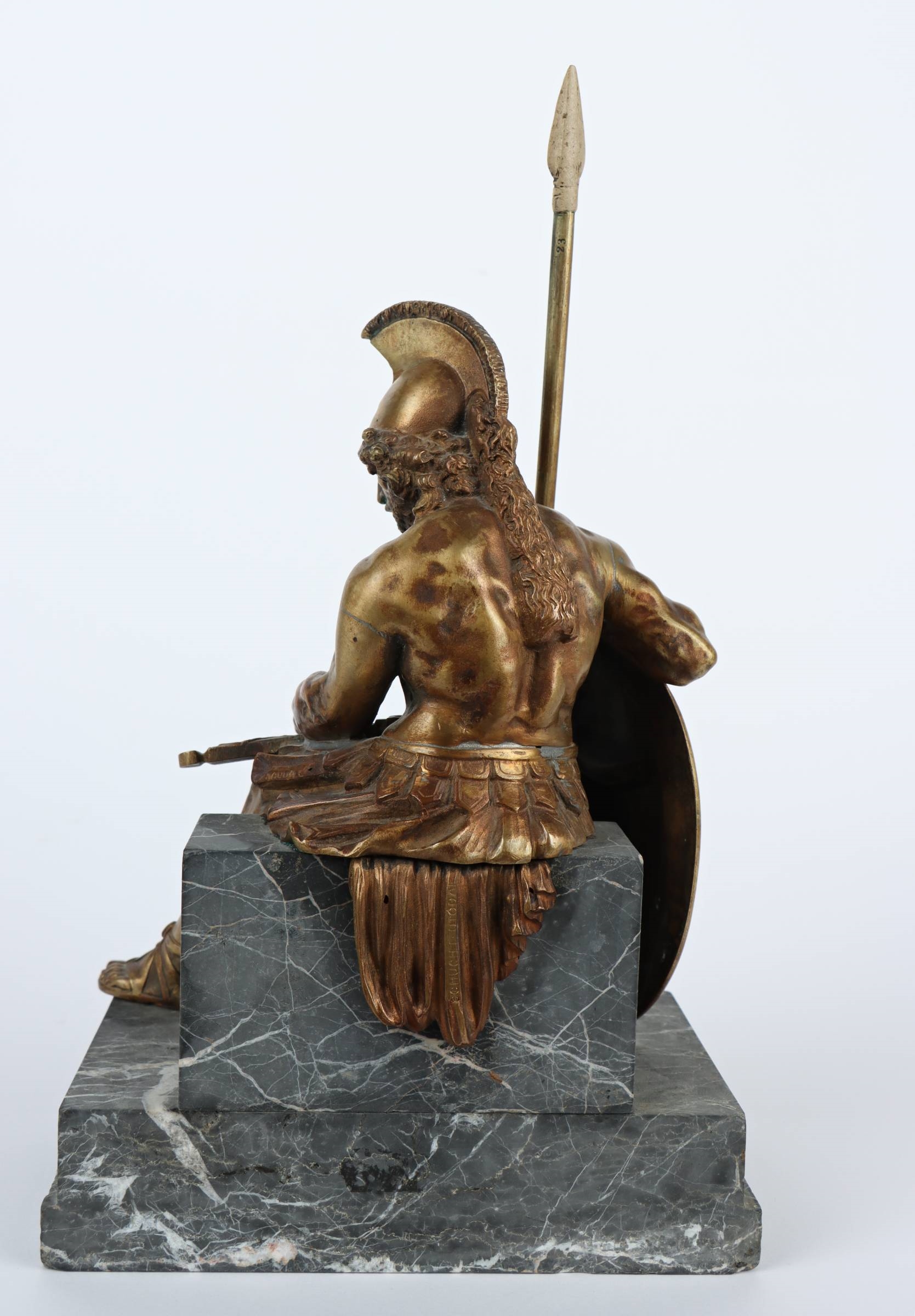 A bronze statue of a man holding a spear and shield.