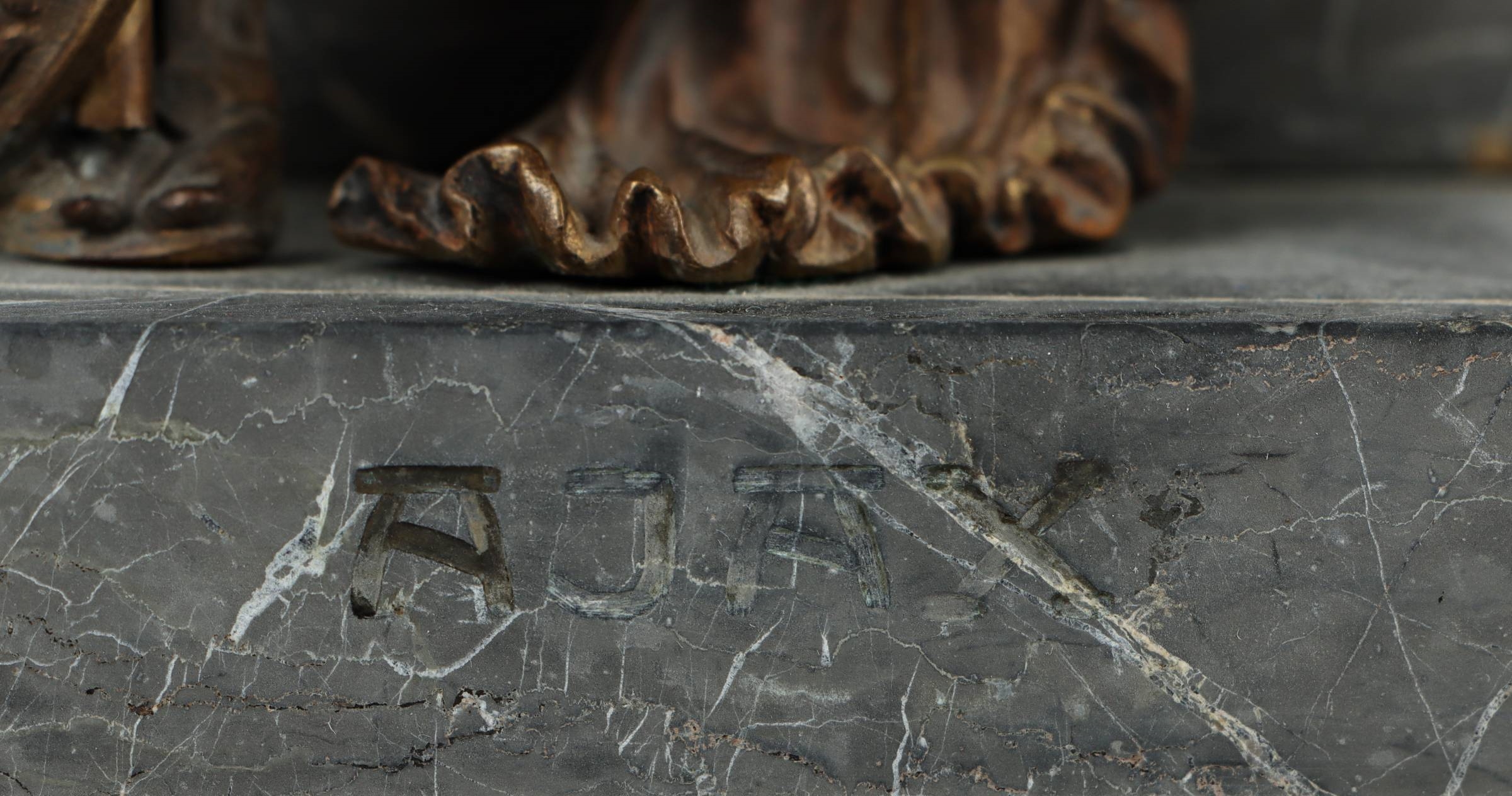 A bronze statue of a man holding a spear and shield.