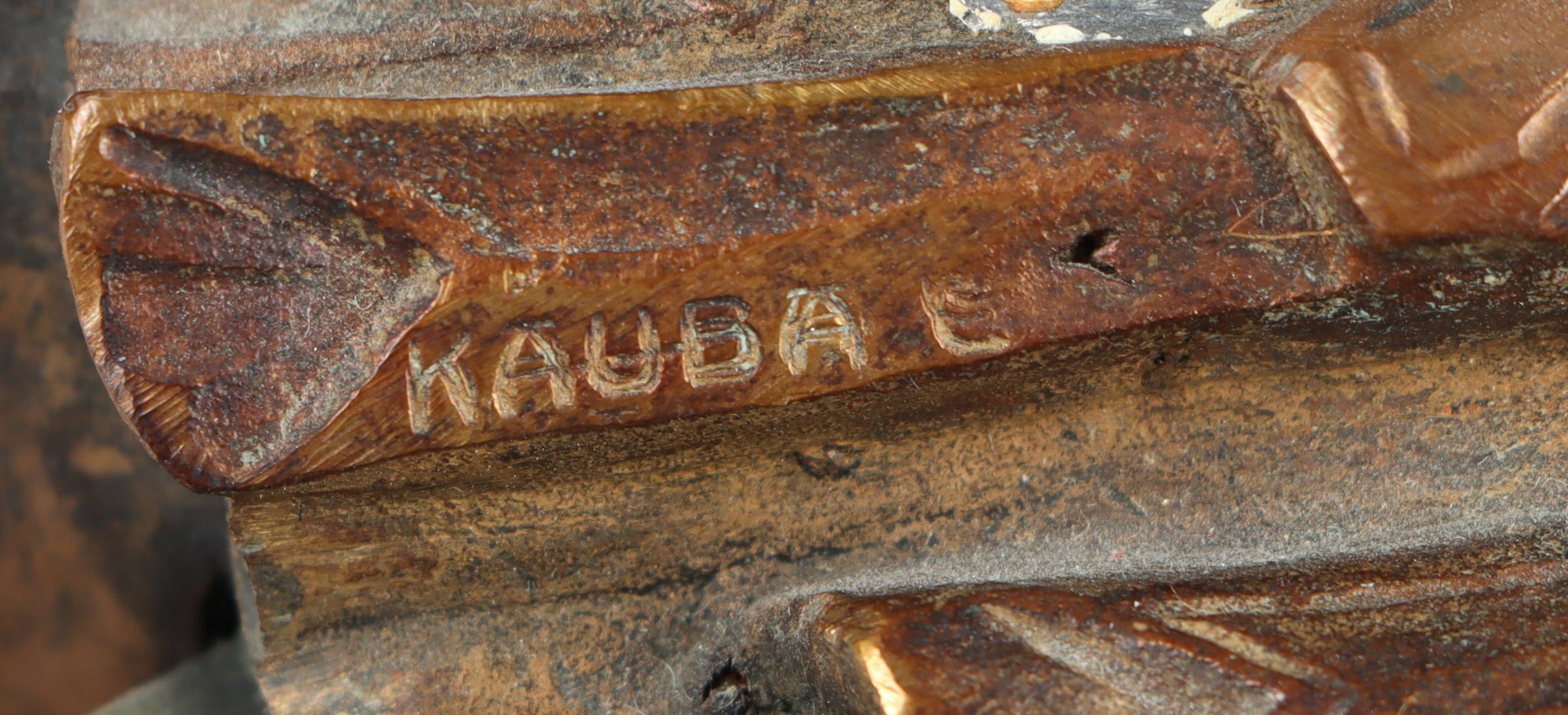 A bronze statue of a man holding a spear and shield.