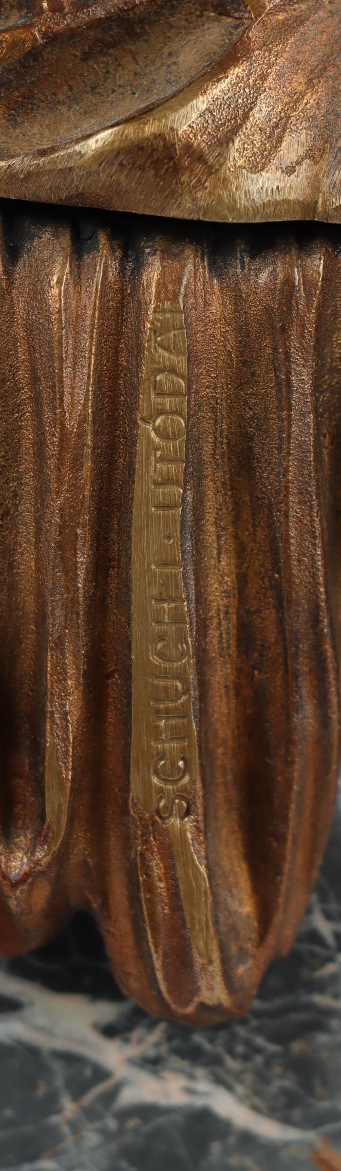 A bronze statue of a man holding a spear and shield.