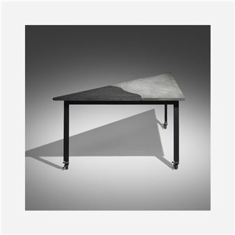 A modernist table with a split-texture top and casters.
