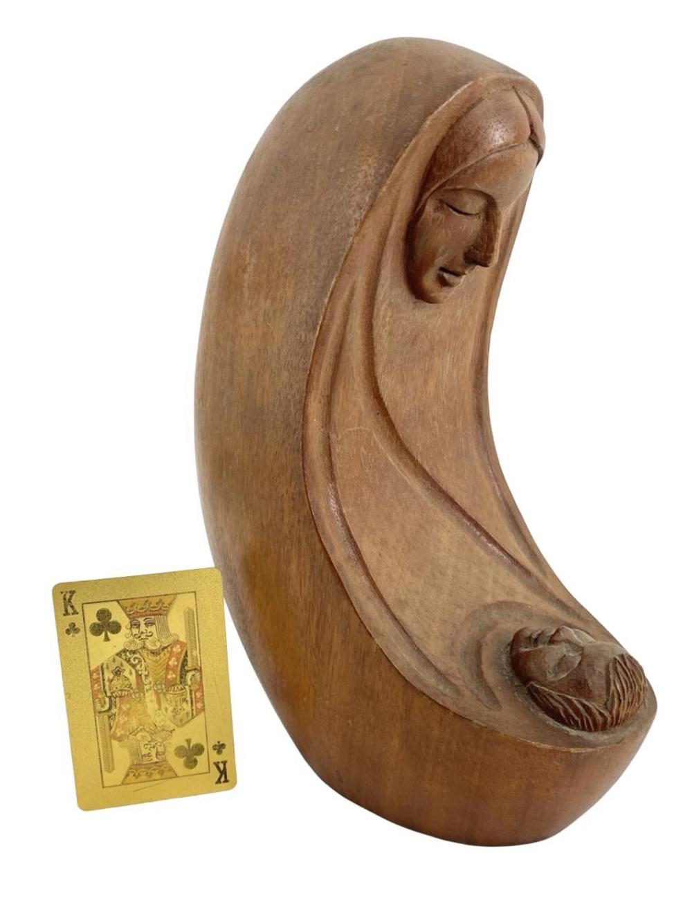 A wooden sculpture of a seated figure cradling a small head.