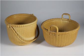 Two woven baskets with handles sit side by side on a neutral background.