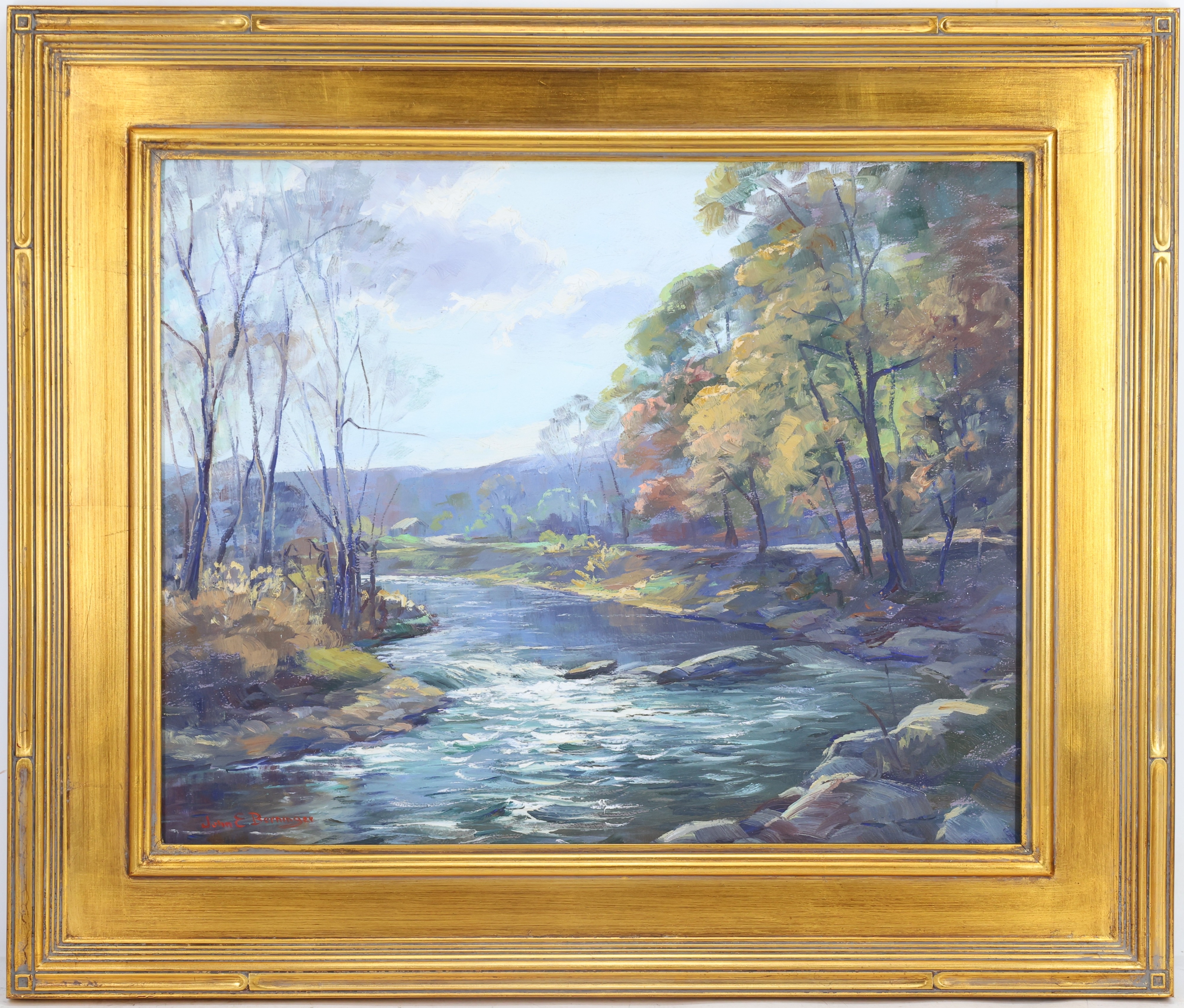 A serene landscape painting of a river flowing through a wooded valley, framed in ornate gold.