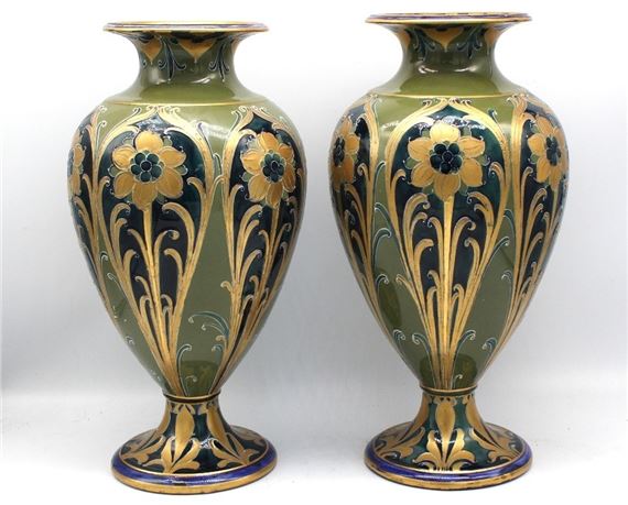 A pair of ornate ceramic vases featuring gold floral motifs on a green and blue background.