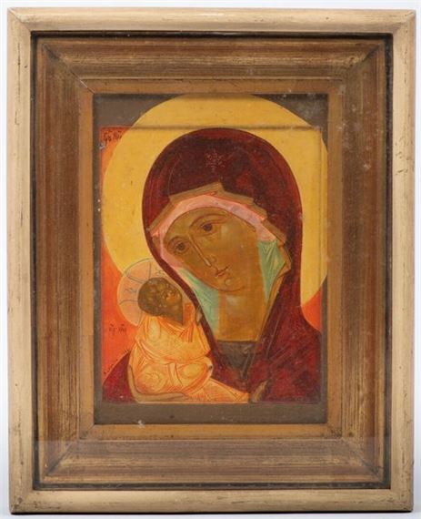 A framed religious icon depicting a mother figure holding a child against a golden background.