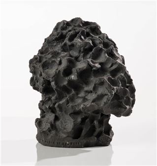 A dark, textured sculpture resembling a crumpled mass or organic form.