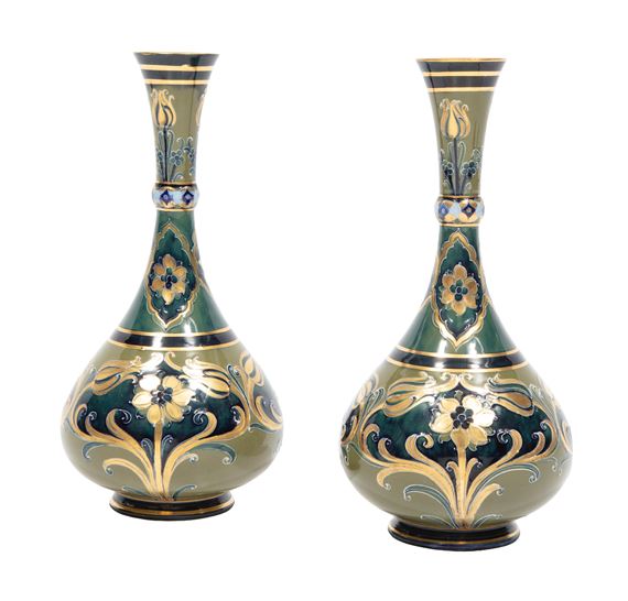 A pair of ornate green and gold vases featuring floral motifs.