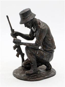 A bronze sculpture of a crouching figure inspecting a rifle.
