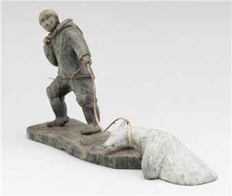 A carved wooden sculpture of a figure dragging a sleeping bear.
