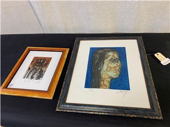 A couple of framed pictures sitting on top of a table.