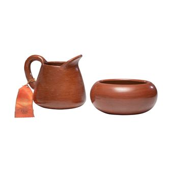A minimalist still life featuring a wooden pitcher with a tag and a matching bowl against a stark white background.
