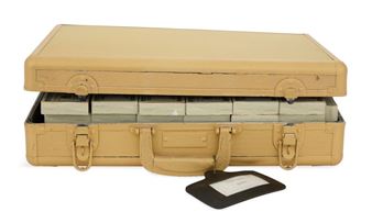 A tan briefcase is open to reveal stacks of cash, with a black card holder resting beside it.