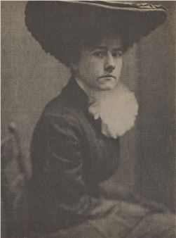 A monochromatic portrait of a seated figure in a wide-brimmed hat and dark attire.