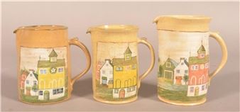 A trio of ceramic pitchers featuring hand-painted village scenes.