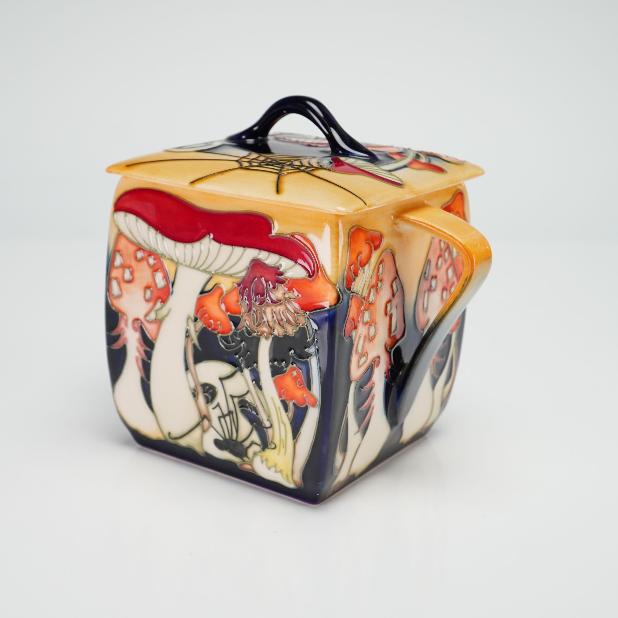 A ceramic sugar bowl featuring a vibrant, stylized forest scene with mushrooms and a fox.