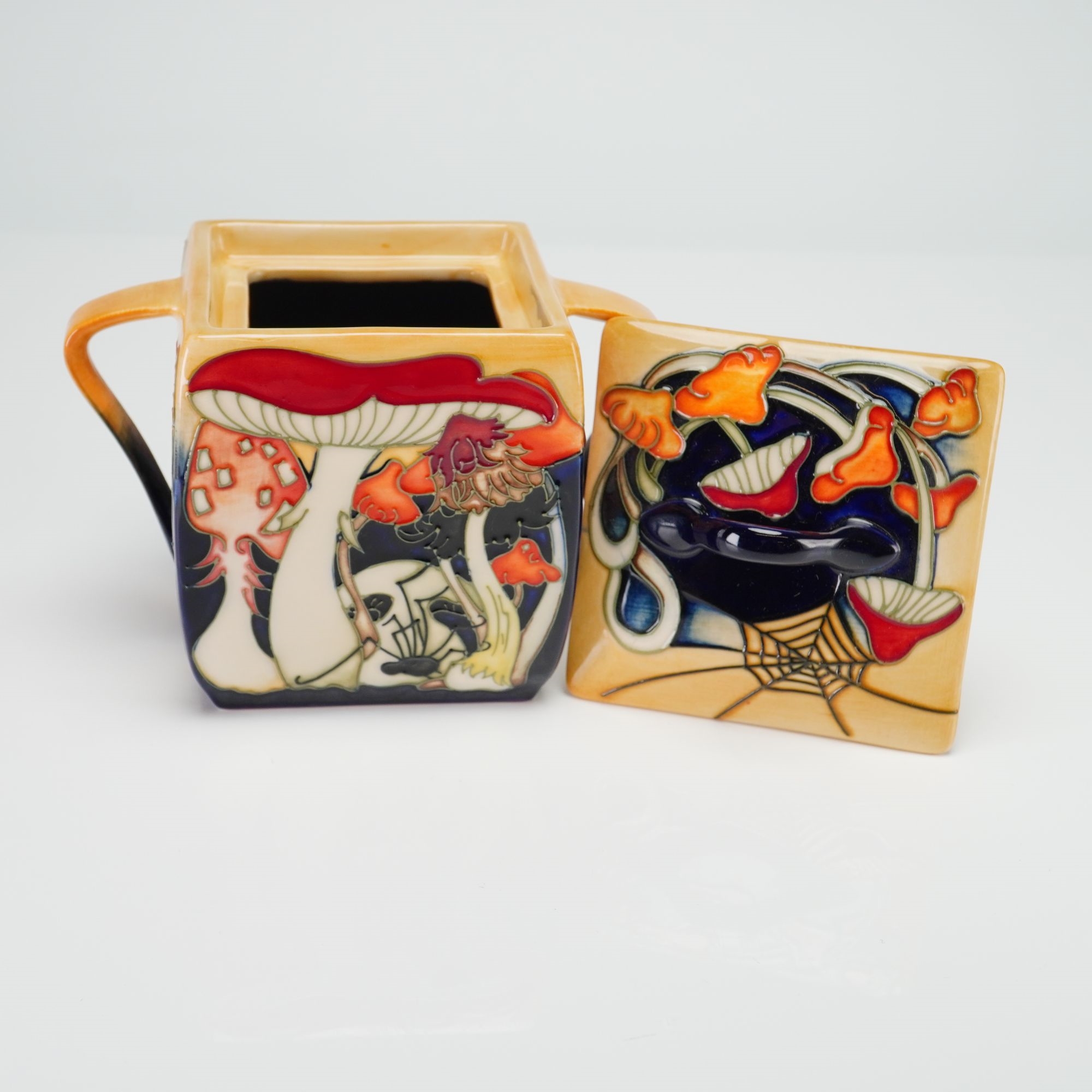A ceramic sugar bowl featuring a vibrant, stylized forest scene with mushrooms and a fox.