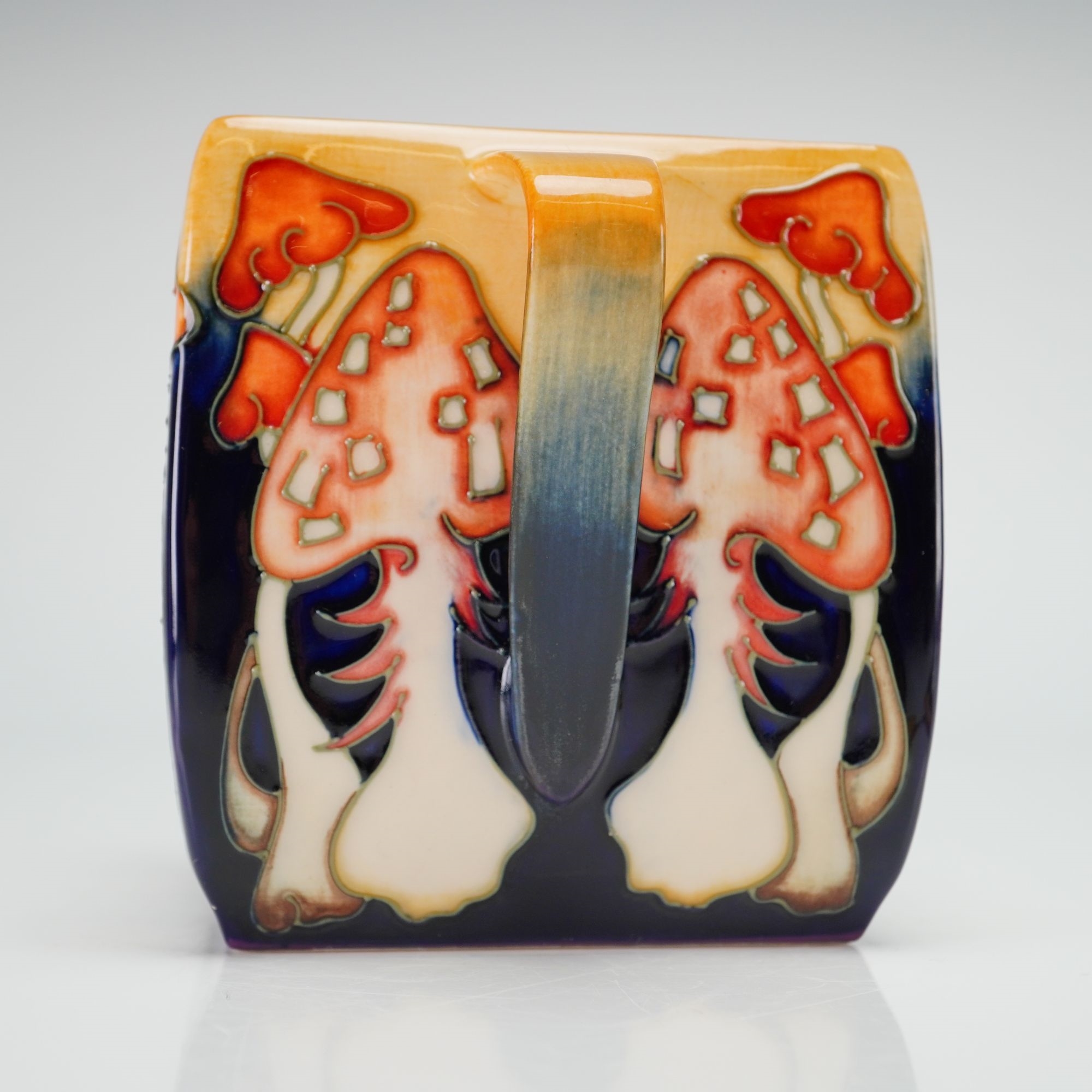 A ceramic sugar bowl featuring a vibrant, stylized forest scene with mushrooms and a fox.