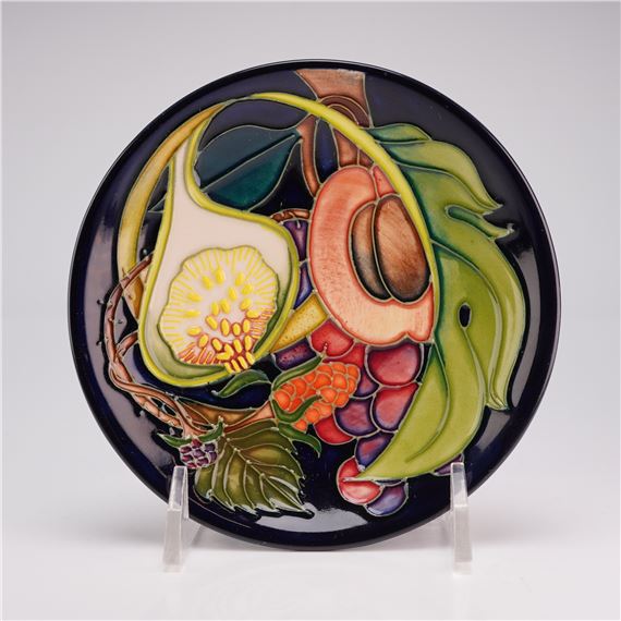 A colorful ceramic plate featuring a vibrant fruit and leaf design.