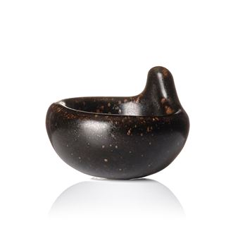A dark, organic bowl with a protruding handle against a stark white background.