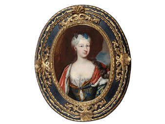 A formal portrait of a woman in an ornate oval frame.