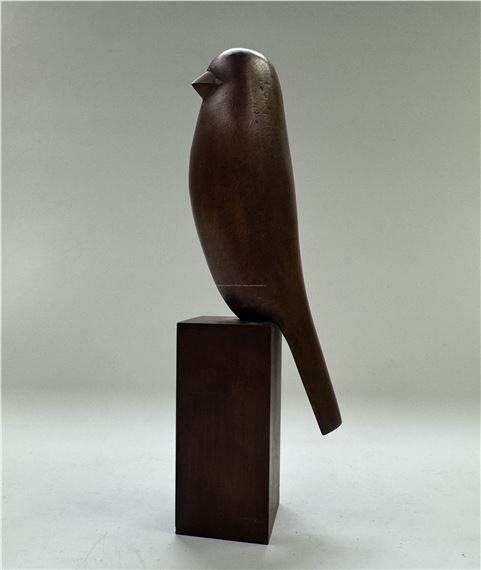 "A minimalist wooden sculpture of a perched bird on a rectangular pedestal."