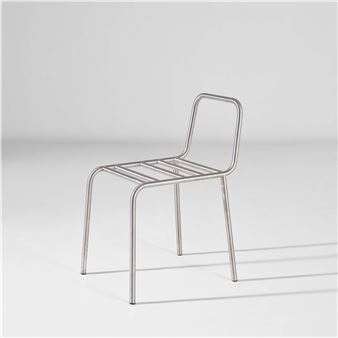 A minimalist metal chair with a sleek, tubular frame and slatted seat against a neutral background.