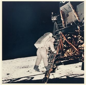 A figure in a bulky white suit climbs a ladder onto a metallic spacecraft on a barren, cratered surface.