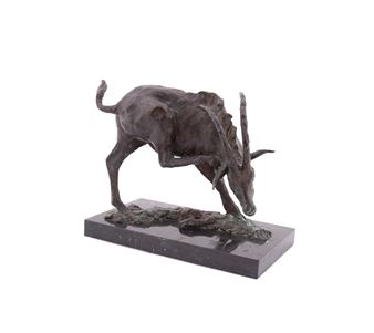 A bronze sculpture of a grazing animal on a dark rectangular base.