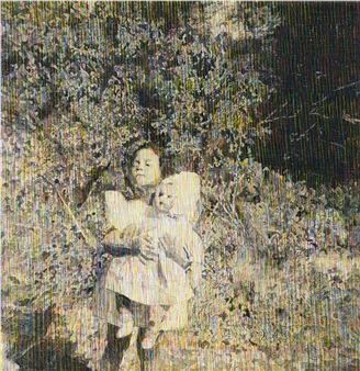 A grainy, textured portrait of a person holding a doll against a backdrop of dense foliage.
