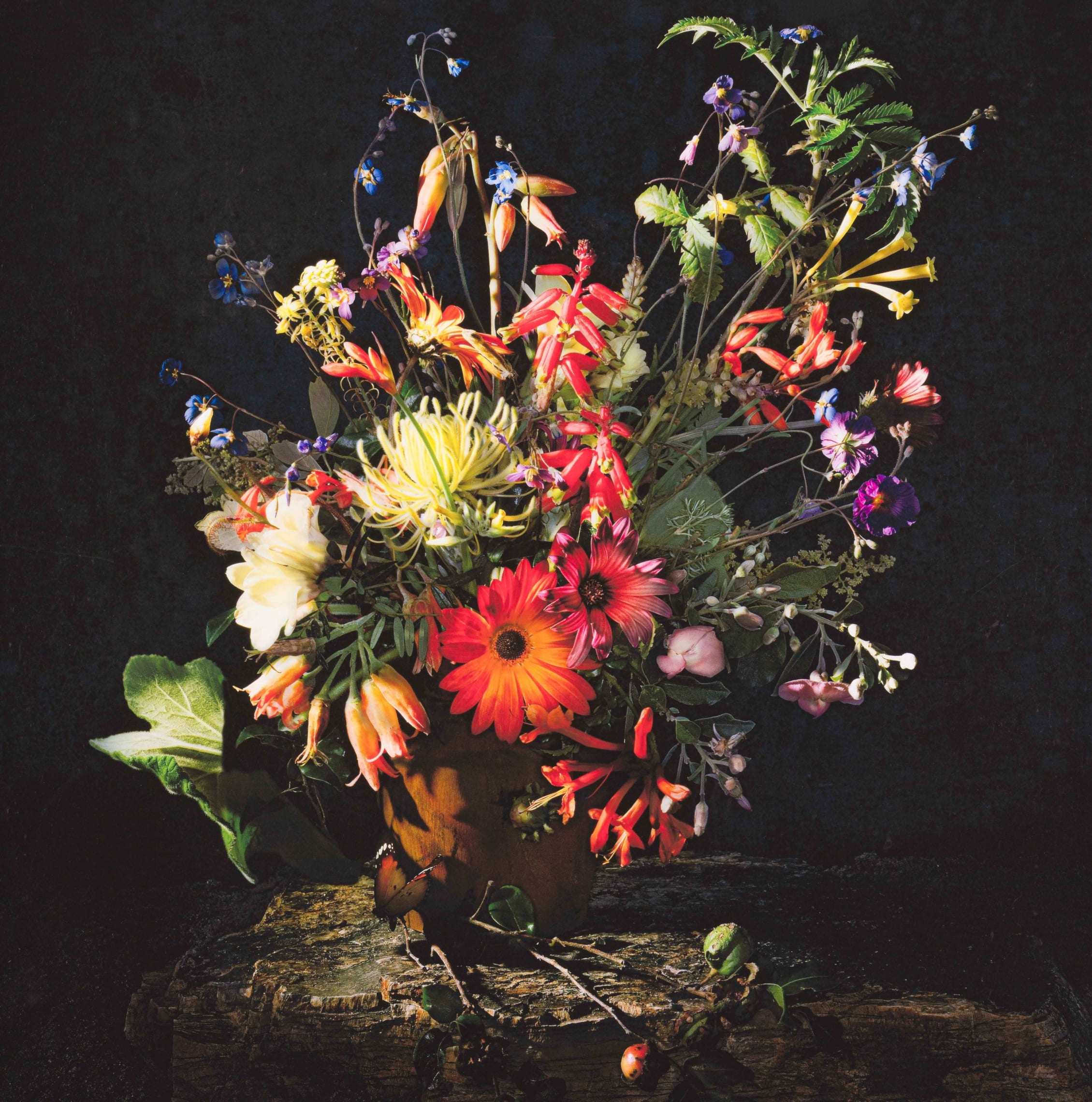 A vibrant still life of wildflowers arranged in a rustic wooden vase.