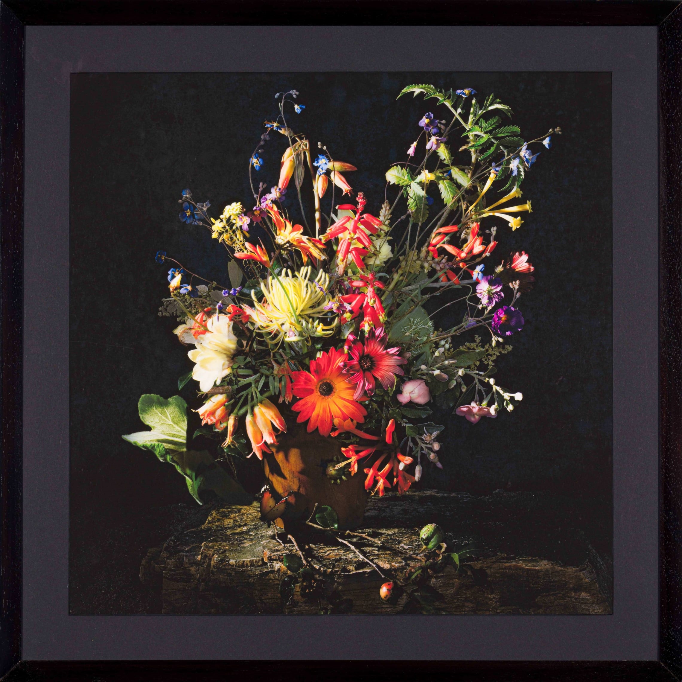 A vibrant still life of wildflowers arranged in a rustic wooden vase.