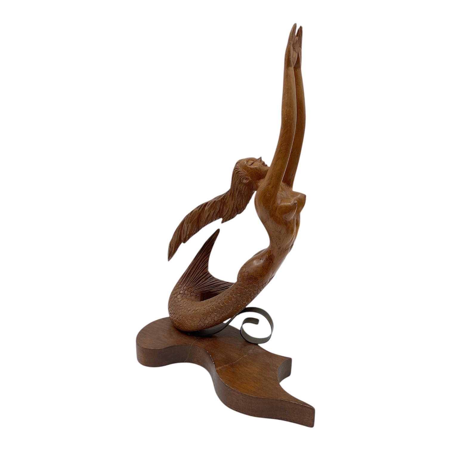 A wooden sculpture of a winged figure with an upward-reaching arm.