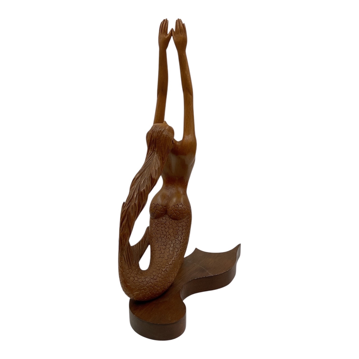 A wooden sculpture of a winged figure with an upward-reaching arm.