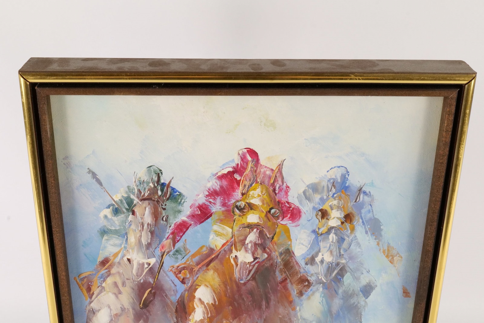 A framed watercolor painting of three galloping horses with vibrant, abstracted colors.