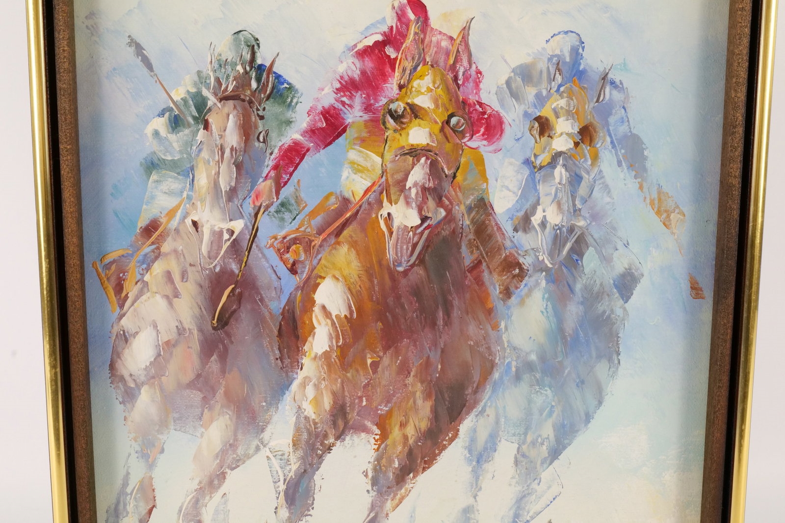 A framed watercolor painting of three galloping horses with vibrant, abstracted colors.