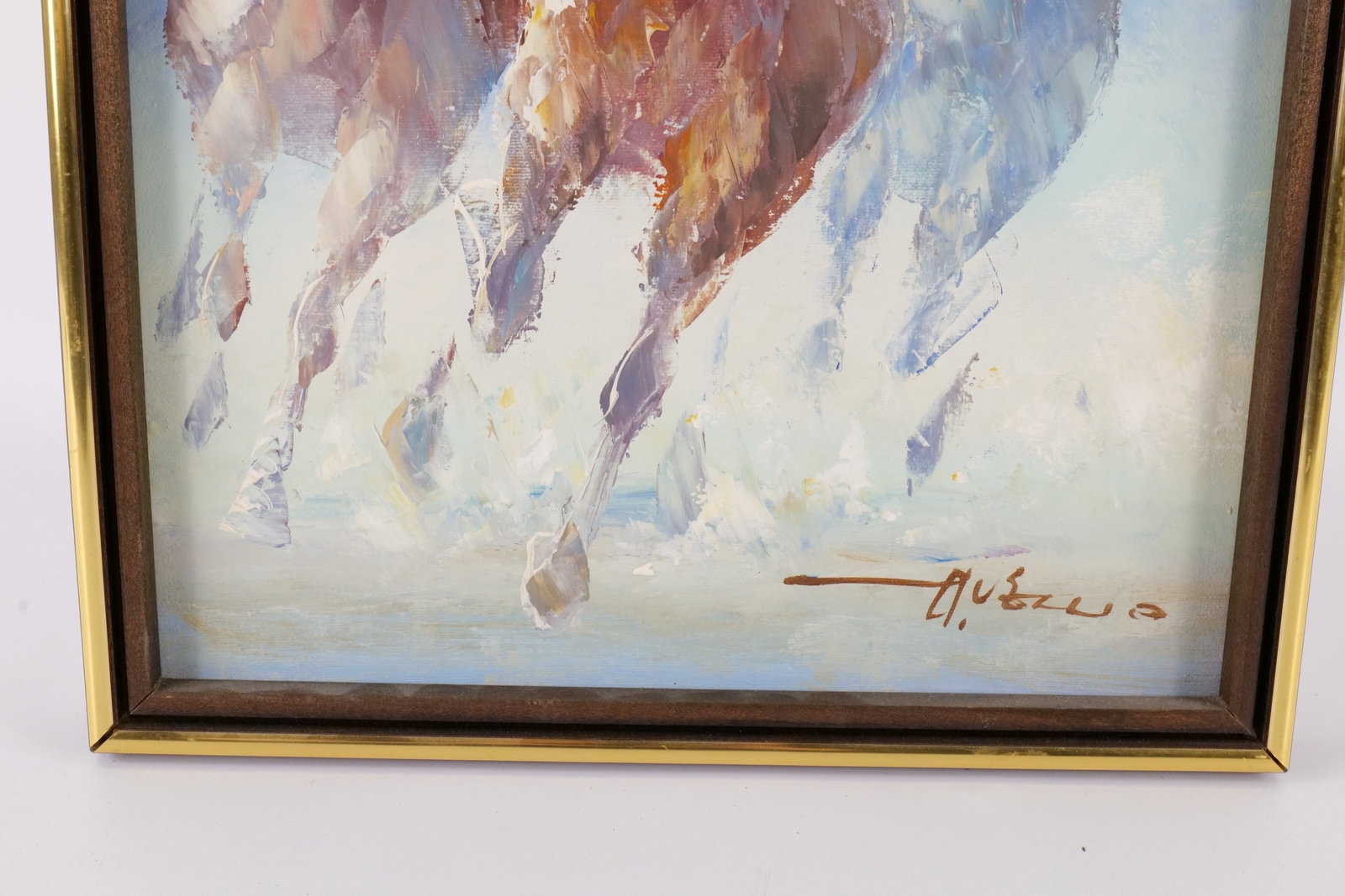 A framed watercolor painting of three galloping horses with vibrant, abstracted colors.